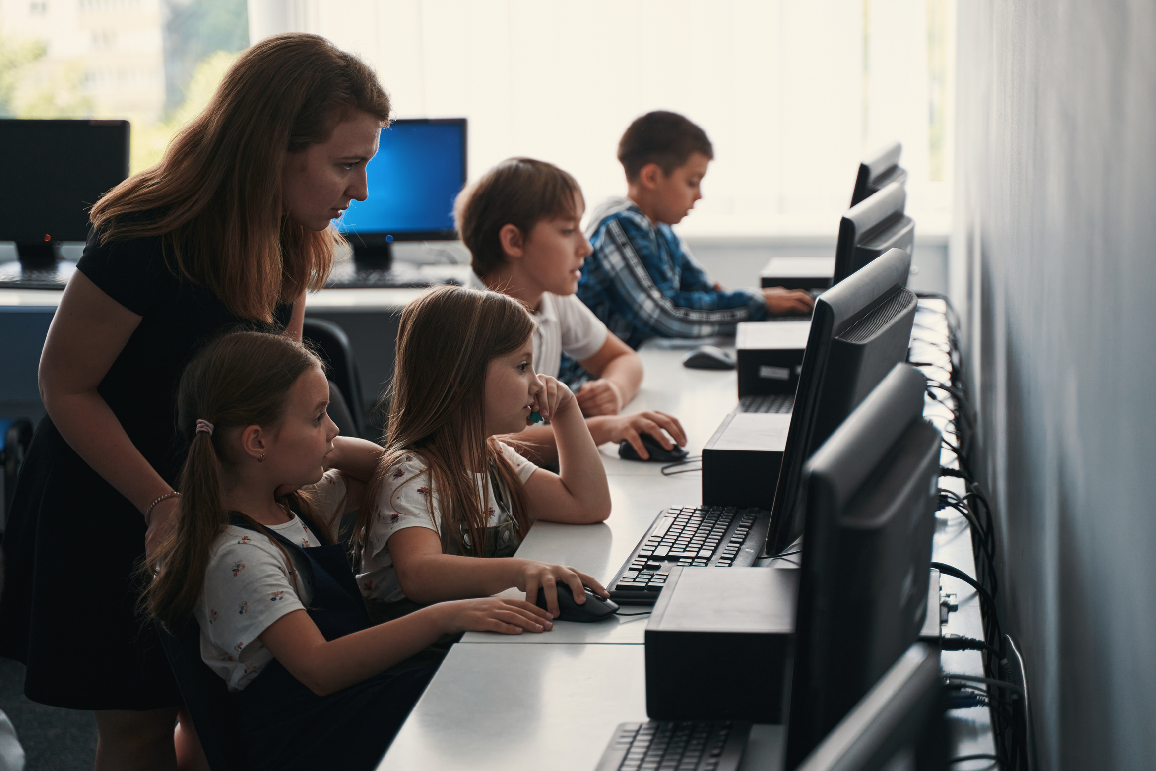 Helpful teacher working in the ICT class